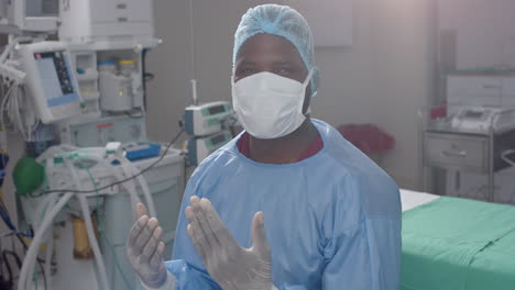 Porträt-Eines-Afroamerikanischen-Männlichen-Chirurgen,-Der-Im-Operationssaal-Ein-Chirurgisches-Kleid-Trägt,-Zeitlupe