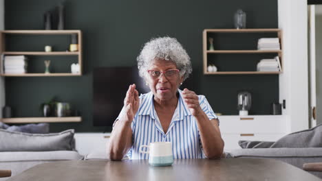 Feliz-Anciana-Afroamericana-Teniendo-Videollamada-En-Casa-Hablando-Y-Saludando,-Cámara-Lenta