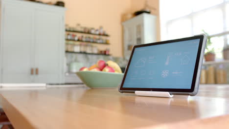 Nahaufnahme-Eines-Tablets-Mit-Smart-Home-Auf-Dem-Bildschirm-über-Obst-In-Einer-Schüssel-In-Der-Küche,-Zeitlupe