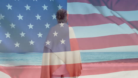 Animation-of-flag-of-usa-over-caucasian-senior-woman-on-beach-in-summer