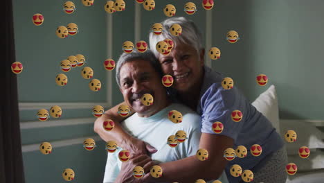 Animation-Von-Emoji-Symbolen-über-Einem-älteren,-Gemischtrassigen-Paar,-Das-Sich-Umarmt