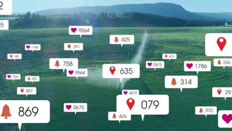 Animation-of-social-media-icons-with-numbers-over-landscape-with-water-sprinkler-on-field