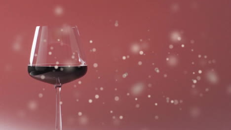 Composite-of-glass-of-red-wine-over-spots-of-light-on-red-background