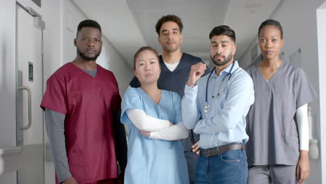 Portrait-of-diverse-male-and-female-doctors-wearing-scrubs-in-hospital-corridor,-slow-motion