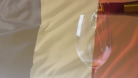 Komposit-Aus-Weißwein,-Der-In-Ein-Glas-über-Dem-Hintergrund-Der-Französischen-Flagge-Gegossen-Wird