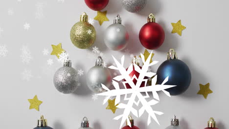 Animation-of-snow-falling-over-christmas-tree-with-baubles