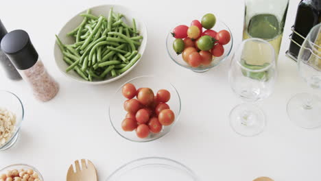 Gemüsesalatzutaten,-Gewürze,-Wein-Und-Gläser-Auf-Der-Küchenarbeitsplatte,-Zeitlupe