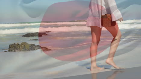 Animation-of-flag-of-japan-over-caucasian-walking-barefoot-and-dancing-on-sunny-beach
