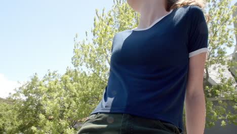 Kaukasische-Frau-In-Marineblauem-T-Shirt-Mit-Weißem-Rand-Im-Sonnigen-Garten,-Kopierraum,-Zeitlupe