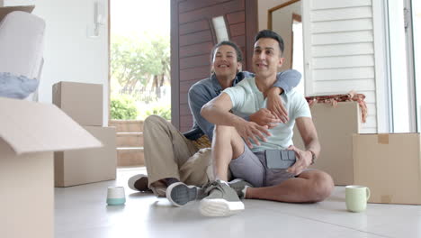 Happy-diverse-gay-male-couple-moving-into-new-home-taking-selfie,-copy-space,-slow-motion