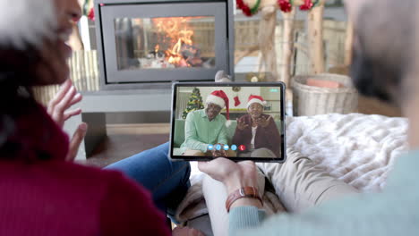 Glückliches,-Vielfältiges-Paar-Und-ältere-Eltern-Mit-Einem-Weihnachtlichen-Tablet-Videoanruf,-Zeitlupe