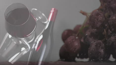 Verbund-Aus-Glas-Und-Flasche-Rotwein-über-Trauben-Und-Grauem-Hintergrund