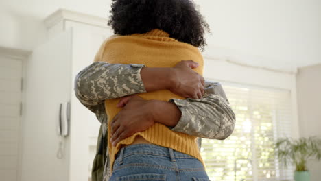 Feliz-Soldado-Afroamericano-Abrazando-A-Su-Esposa-En-Casa,-Cámara-Lenta