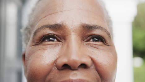 Portrait-close-up-of-happy-senior-african-american-woman-smiling-in-garden,-slow-motion