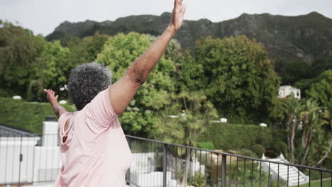 Fokussierte-ältere-Afroamerikanische-Frau,-Die-Yoga-Praktiziert,-Steht-Auf-Dem-Balkon,-Kopierraum,-Zeitlupe