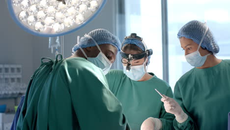 Portrait-of-african-american-male-surgeon-during-operation-with-diverse-colleagues,-slow-motion
