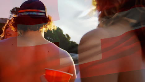 Animation-of-flag-of-switzerland-over-diverse-friends-dancing-and-drinking-a-toast-on-sunny-beach