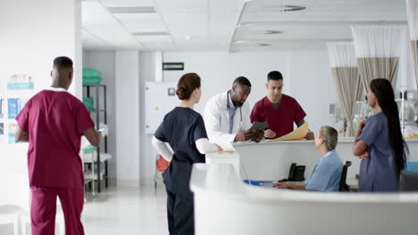 Diversos-Médicos-Discutiendo-El-Trabajo,-Usando-Tabletas-En-La-Recepción-Del-Hospital,-Cámara-Lenta