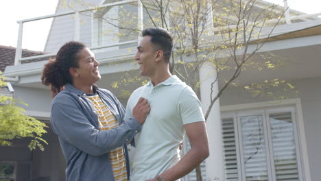 Portrait-of-happy-diverse-gay-male-couple-with-new-house-keys-embracing-in-garden,-slow-motion