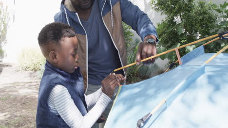 African-American-father-and-son-set-up-a-tent-outdoors