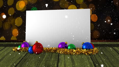 Animation-of-snow-falling-over-white-card-with-copy-space-and-christmas-decorations