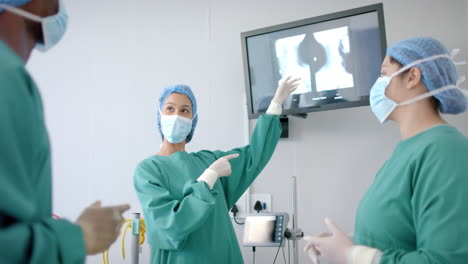 Verschiedene-Chirurginnen-Und-Chirurgen-In-Masken-Diskutieren-Röntgen-Im-Operationssaal,-Zeitlupe