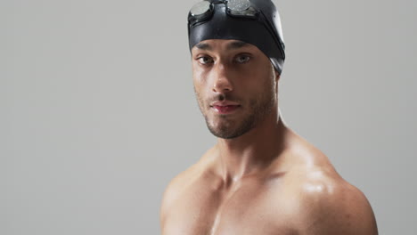 Young-biracial-athlete-swimmer-wearing-swimming-goggles,-with-copy-space