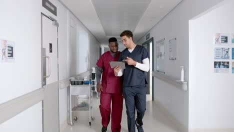 Diverse-healthcare-professionals-discuss-in-a-hospital-corridor