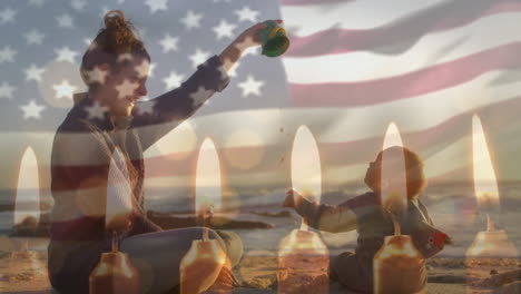Animation-of-american-flag-and-candles-over-caucasian-mother-and-child-playing-on-beach