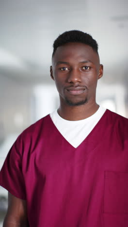 Vídeo-Vertical-Del-Retrato-De-Un-Feliz-Médico-Afroamericano-En-El-Hospital,-Cámara-Lenta