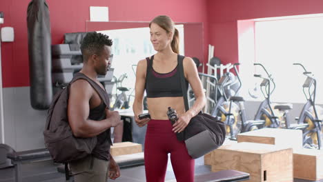 Fit-African-American-man-chats-with-a-young-Caucasian-woman-at-the-gym