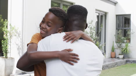 African-American-father-and-son-share-a-warm-hug-outdoors