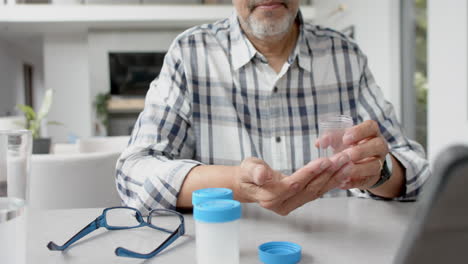 Älterer-Mann-Mit-Gemischter-Abstammung-Und-Medikamenten-Führt-Videoanruf-Mit-Arzt-Auf-Tablet,-Zeitlupe
