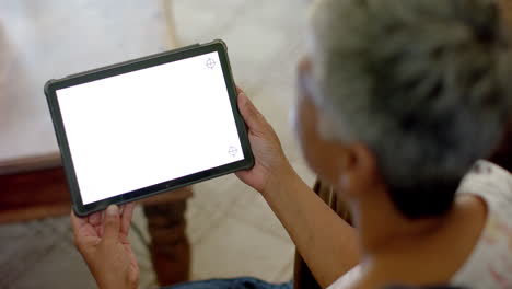 Senior-biracial-woman-using-tablet-with-copy-space-at-home,-slow-motion