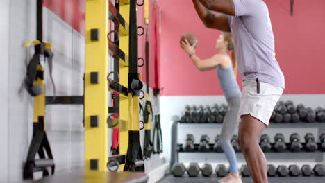 Fitter-Afroamerikanischer-Mann-Und-Junge-Kaukasische-Frau-Trainieren-Im-Fitnessstudio-Mit-Medizinball