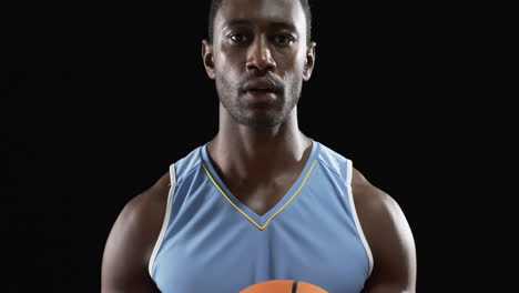 Fokussierter-Afroamerikanischer-Athlet,-Der-Einen-Basketball-Auf-Schwarzem-Hintergrund-Hält