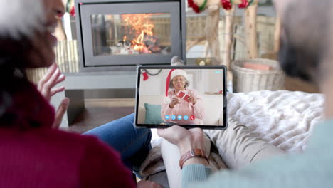 Happy-diverse-couple-and-senior-mother-having-christmas-tablet-video-call,-slow-motion