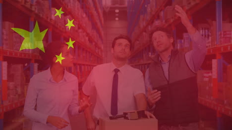 Animation-of-flag-of-china-over-diverse-male-and-female-colleagues-discussing-in-warehouse