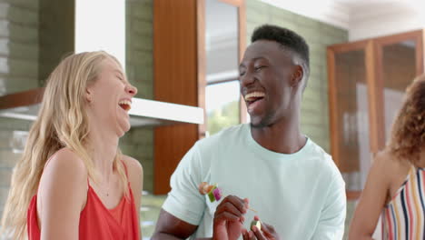 Young-African-American-man-shares-a-joyful-moment-with-a-young-Caucasian-woman-at-home
