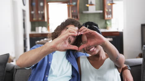 Young-couple-forms-a-heart-shape-with-hands-at-home