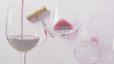 Composite-of-red-wine-being-poured-into-glasses-and-corkscrew-on-white-background
