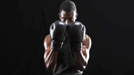 Boxeador-Afroamericano-Preparado-En-Una-Postura-Defensiva-Sobre-Un-Fondo-Negro