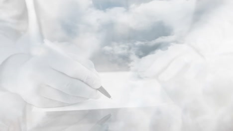Animation-Von-Wolken-über-Händen,-Die-In-Ein-Buch-Schreiben