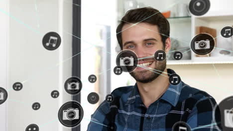 Animation-of-network-of-connected-icons-in-circles-over-happy-caucasian-man-using-smartphone
