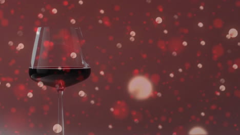 Komposit-Aus-Einem-Glas-Rotwein-über-Lichtflecken-Auf-Rotem-Hintergrund