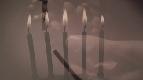 Animation-Eines-Kreuzes-über-Brennenden-Kerzen-Und-Händen,-Die-Einen-Rosenkranz-Halten