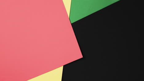 Video-of-red,-yellow-and-green-papers-with-copy-space-on-black-background