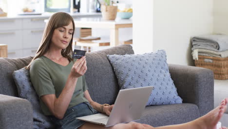 Middle-aged-Caucasian-woman-shops-online-from-home,-with-copy-space
