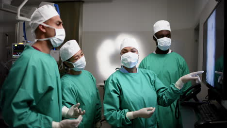 Diversos-Cirujanos-Discutiendo-Con-Exploraciones-De-Rayos-X-En-El-Quirófano-Del-Hospital,-Cámara-Lenta