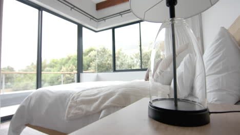 Interior-of-domestic-bedroom-with-double-bed-and-corner-windows-over-garden,-copy-space,-slow-motion